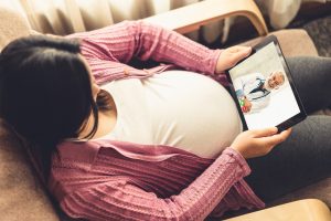 pregnant woman consulting with ob/gyn via tablet for telehealth
